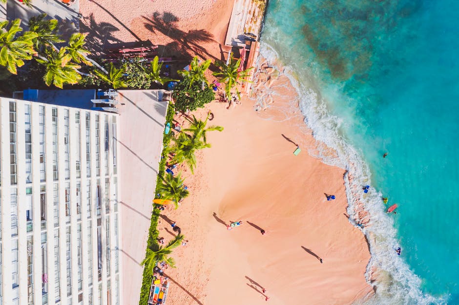 Discover the vibrant beauty of a tropical beach from above, showcasing crystal blue waters and sandy shores.