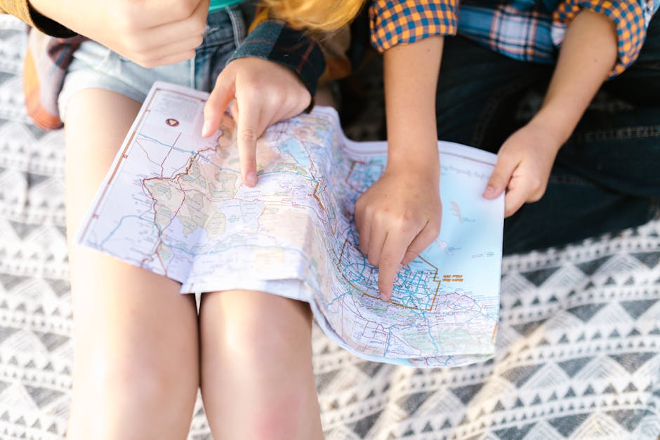 Two children point to a location on a map, planning a fun outdoor adventure.